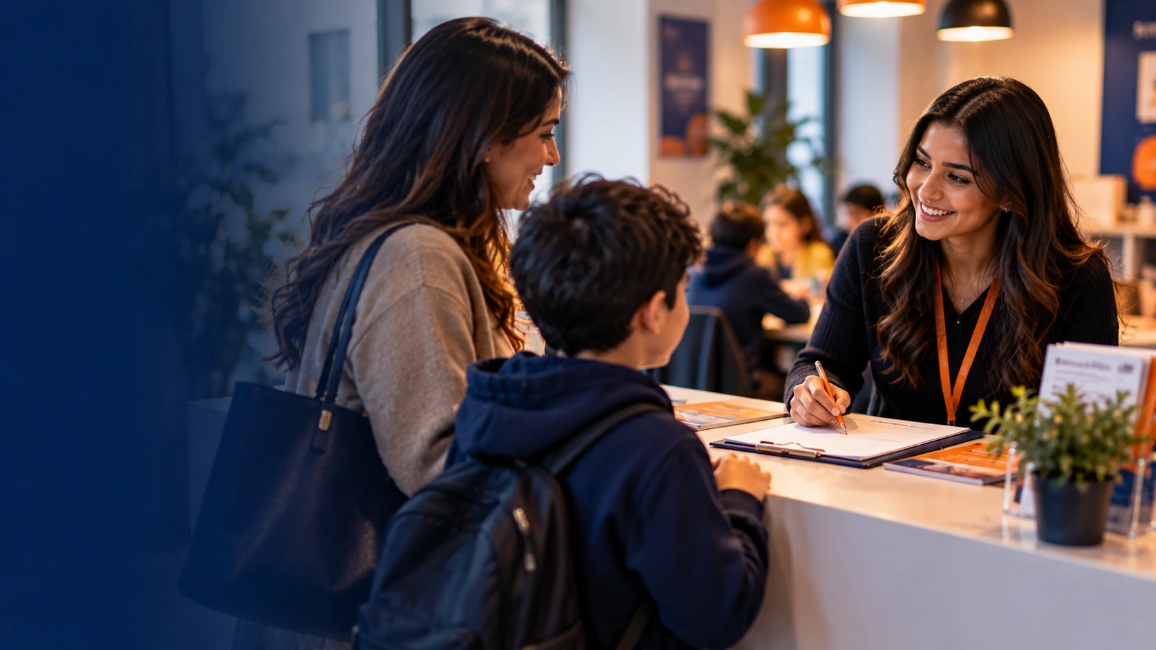 Parent and child talking with a smiling member of staff at a reception desk