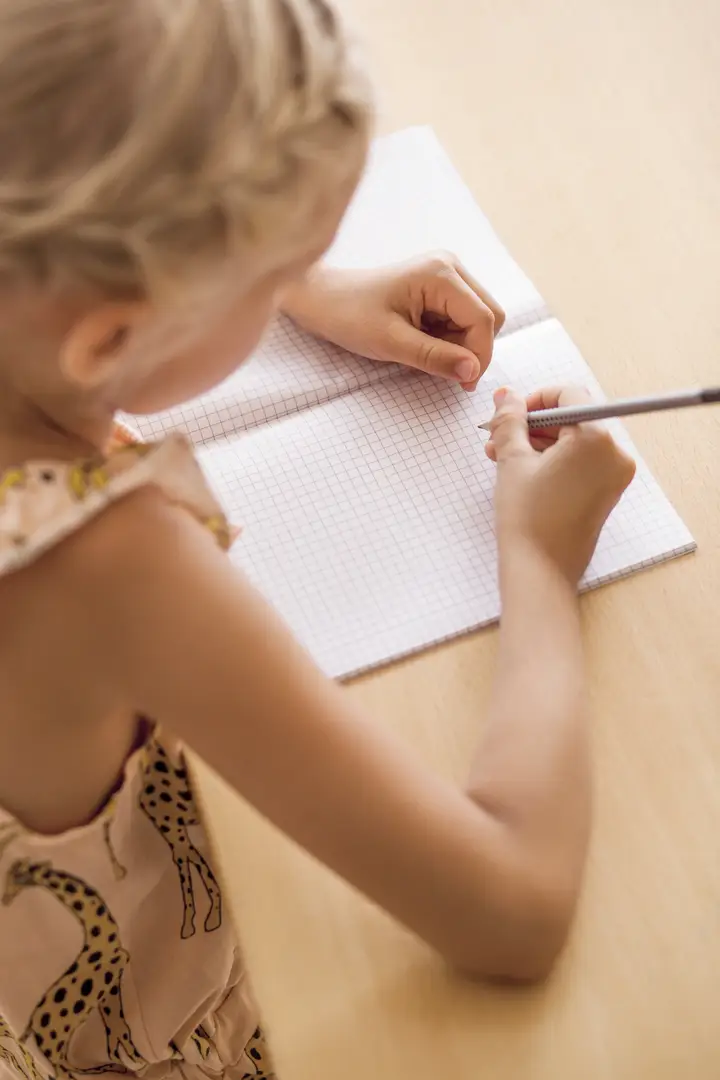 Child writing in a squared maths notebook