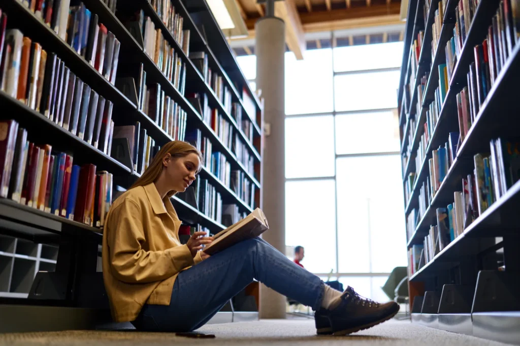Sixth-form student reading through notes in a library