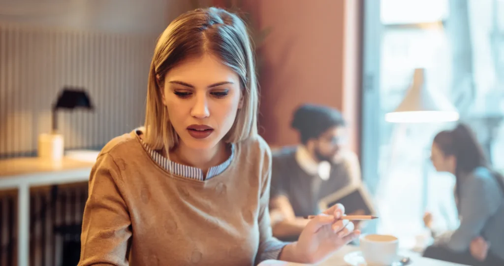 Student studying with a laptop and notes at a table