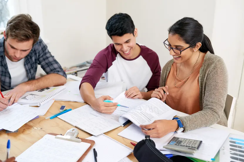 Tutor helping sixth-form students with A-Level Maths problems